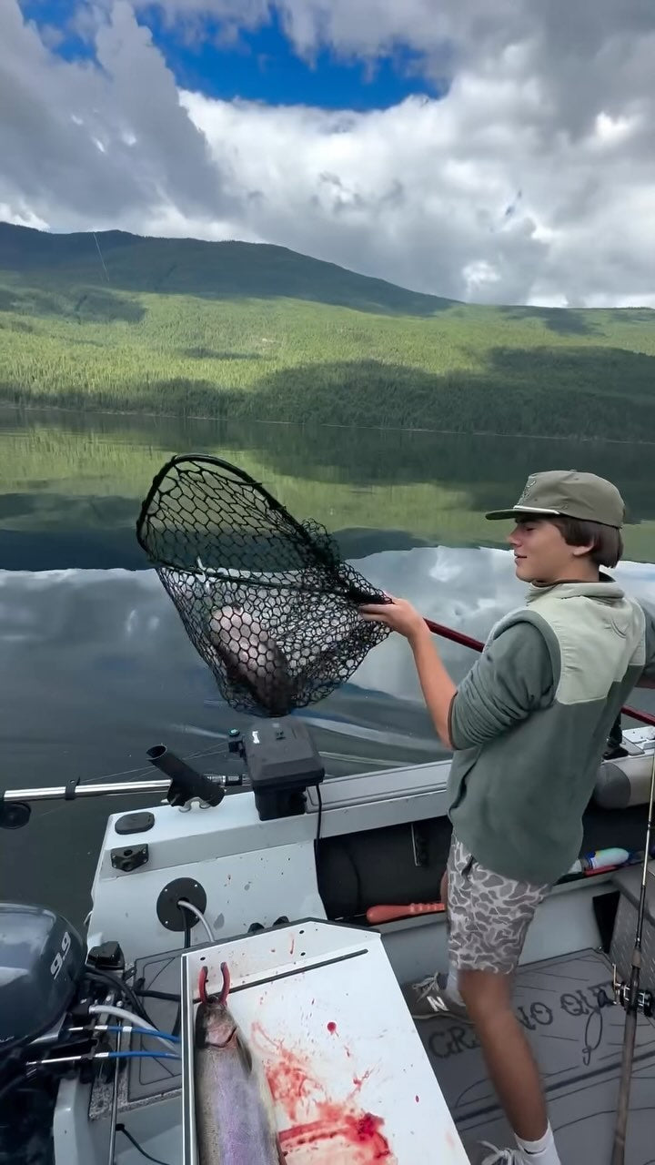 A person holding a net with a fish in it